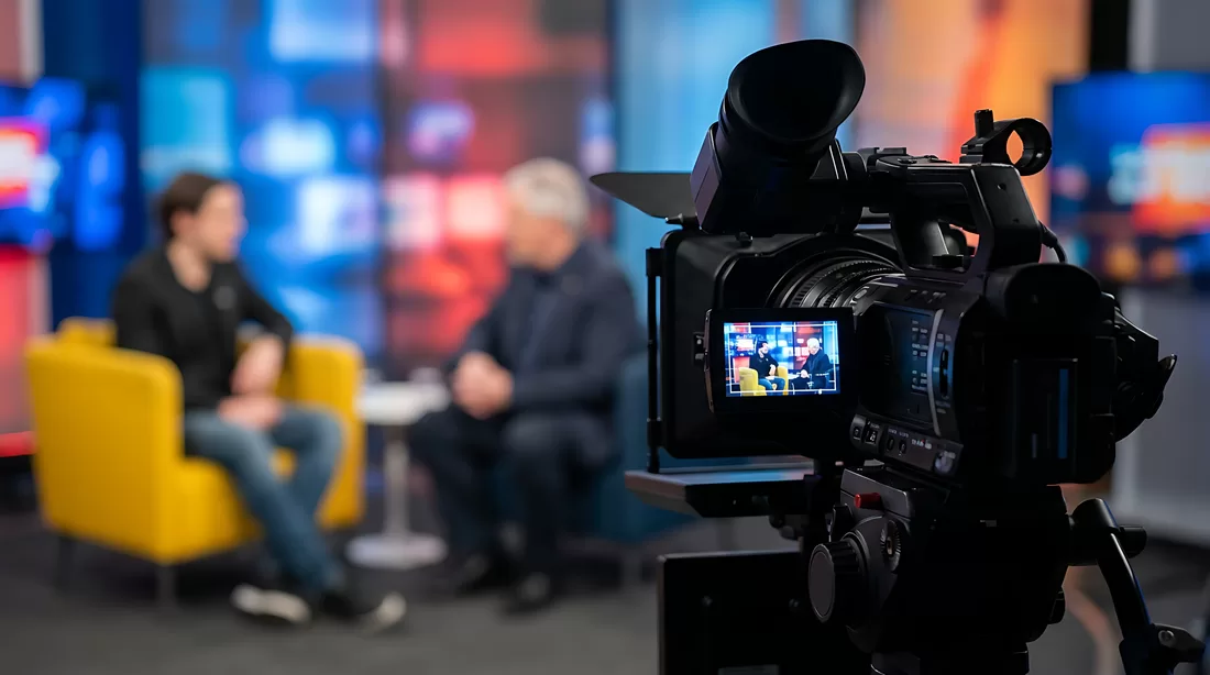 Broadcast studio camera filming a newsroom interview